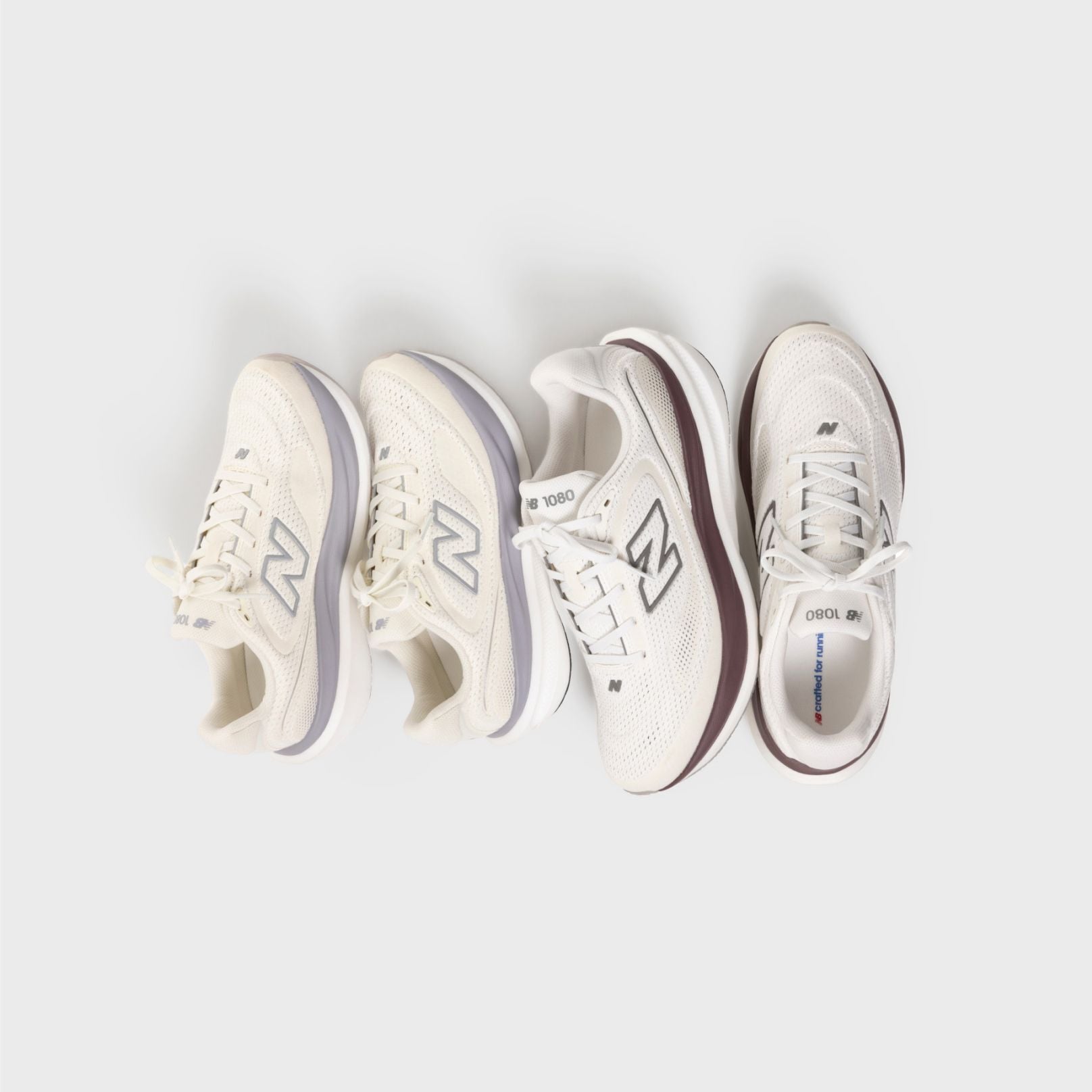 Two pairs of 1080 shoes on a grey background.